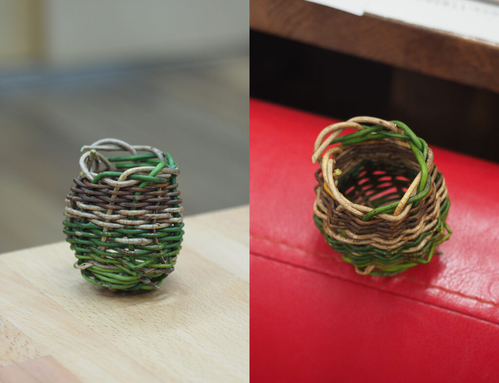 緑と白と茶色のツルで編まれた小さな縦長のかご